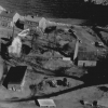 <p>Aerial view of Battery Practice and vicinity, January 1932. Concrete retaining wall and earth parapet are visible behind tall chimney at center right.</p>